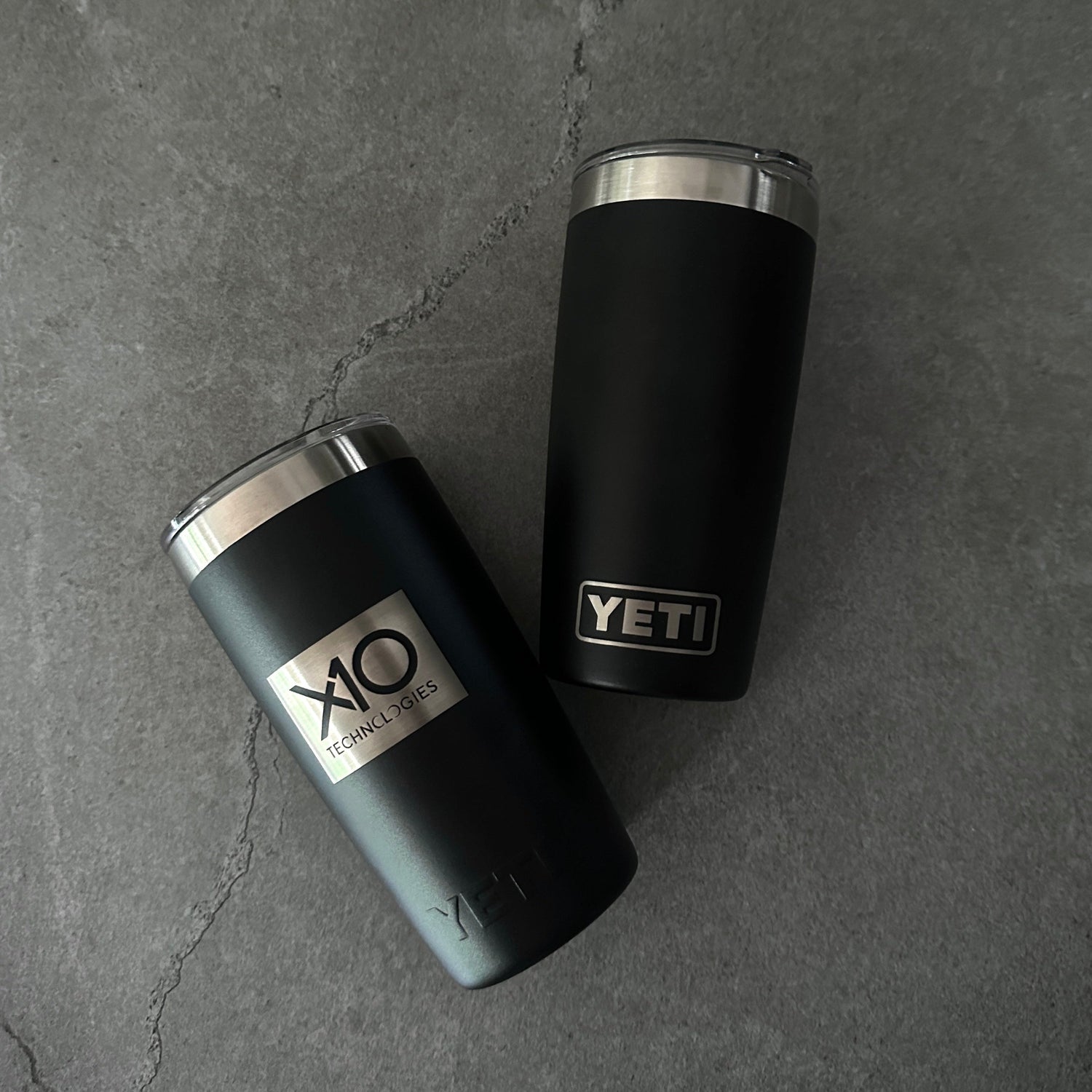 Two black Yeti tumblers on a gray surface
